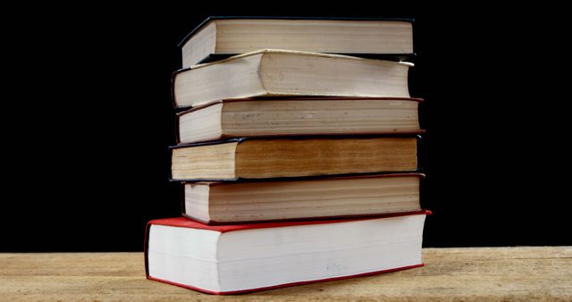 Stack of old books on wooden table against black background - Download Free Stock Images Pikwizard.com