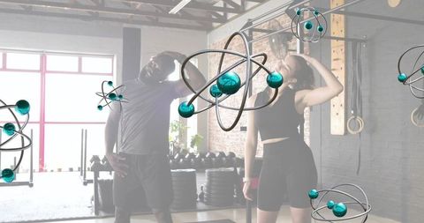 Pair stretching in industrial gym with floating atom models, crossfit fitness lifestyle