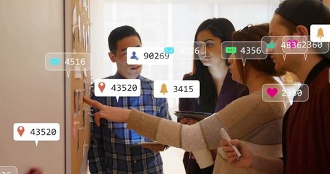 Marketing team analyzing social media engagement metrics on corkboard for strategy session
