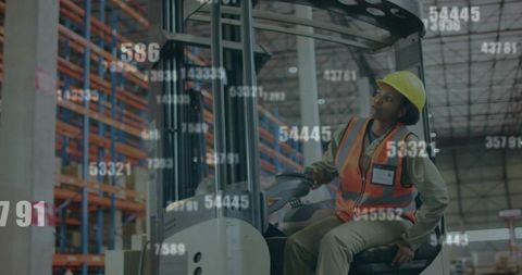 Driving forklift in warehouse wearing hardhat and high-visibility vest with data overlay