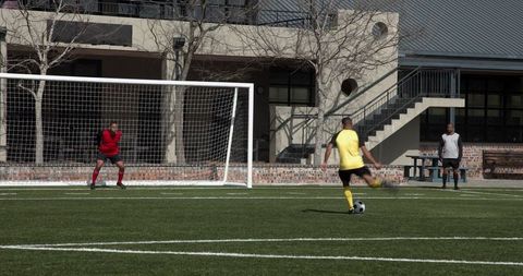 Soccer player taking penalty kick outdoors during match