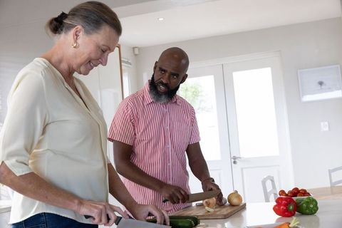 Senior Couple Preparing Vegetables Together in Home Kitchen