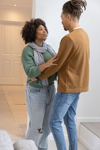 African american couple sharing intimate conversation while holding forearms in cozy home entry