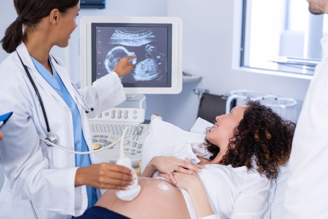 Doctor conducting ultrasound scan for pregnant woman in hospital. Perfect for illustrating prenatal care, maternity services, and healthcare providers. Useful for medical websites, prenatal care articles, and educational materials about pregnancy.
