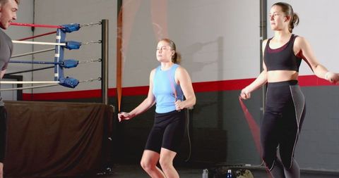 Energetic trio skipping rope in boxing ring during high-intensity cardio training session