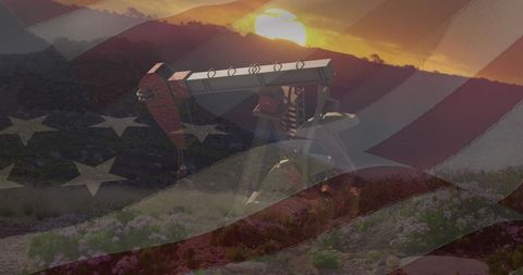 Oil pump jack silhouette against usa flag at sunset
