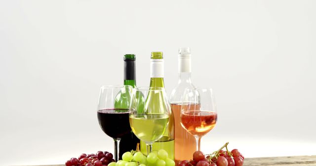 A selection of wine bottles and glasses paired with fresh grapes, with copy space. The arrangement suggests a wine tasting event or a social gathering centered around enjoying different types of wines.