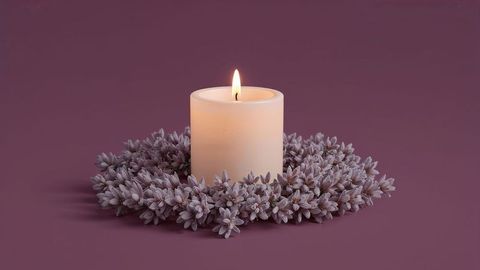 Serene white pillar candle with lavender wreath on purple surface