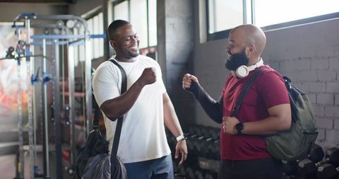 African men fist bumping at gym after workout showing camaraderie and fitness motivation