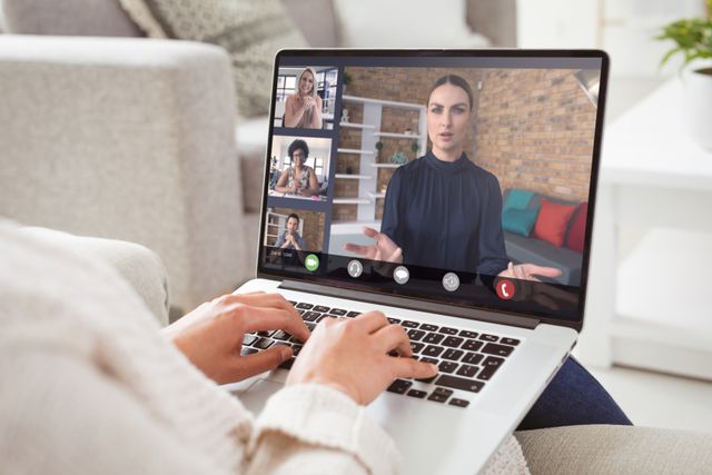 Multiracial colleagues with caucasian businesswoman during video call on laptop at home. unaltered, work from home, business, wireless technology, working, teamwork and office concept.