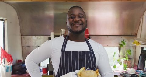 Smiling Business Owner Serving Meal from Food Truck