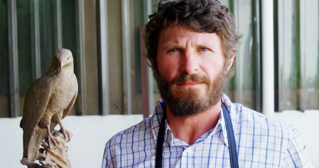 Portrait of Bearded Man Posing Beside Bird Sculpture - Download Free Stock Photos Pikwizard.com