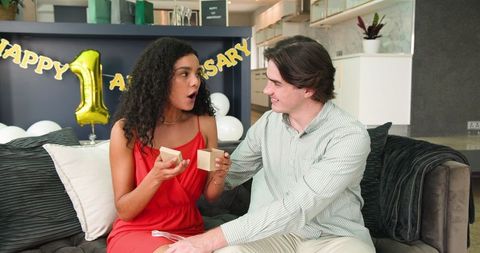 Couple exchanging gifts celebrating an anniversary at home