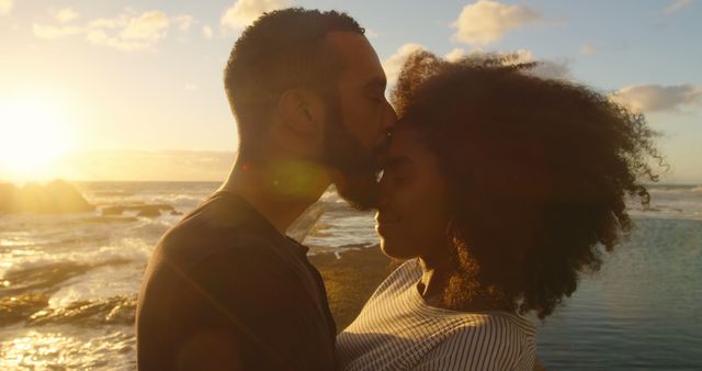 Romantic diverse couple embracing and kissing on beach at sunrise copy space. Summer, vacation, romance, love, relationship, free time and lifestyle, unaltered.