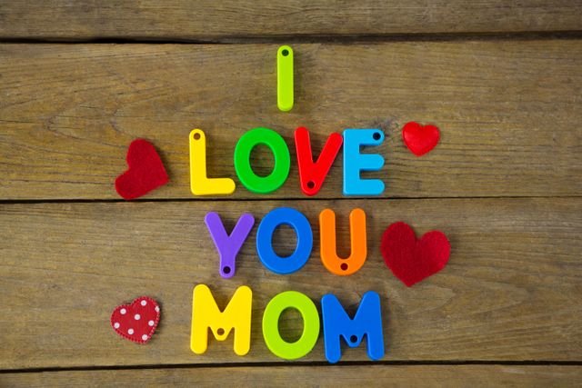 I love you mom message with red hearts on wooden plank
