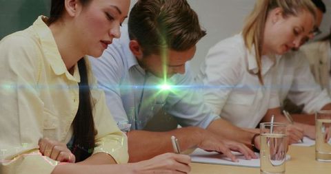 Focused students writing at desk with overlay effect in classroom setting