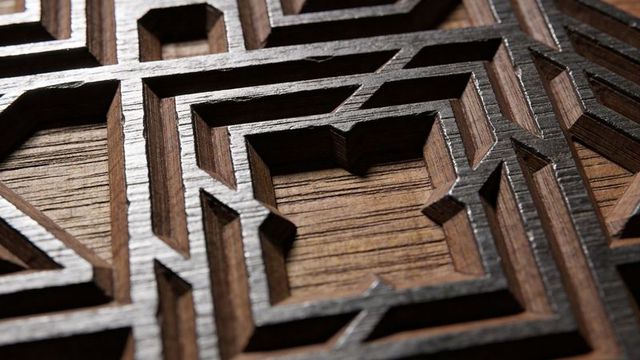 Carved wooden lattice panel showcasing geometric star and polygon motifs closeup