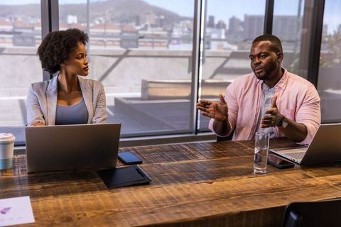 African American Colleagues Discussing Report in Modern Office