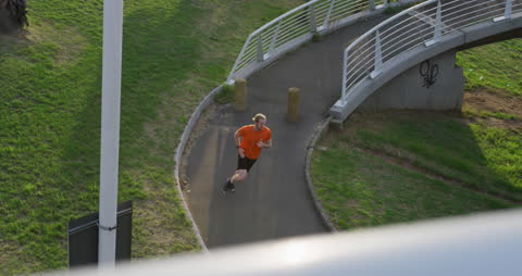 Athletic Man Running on Urban Footbridge for Exercise