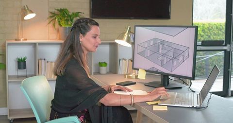 Indian woman working on laptop with 3d floor plan on monitor, home studio architect designing