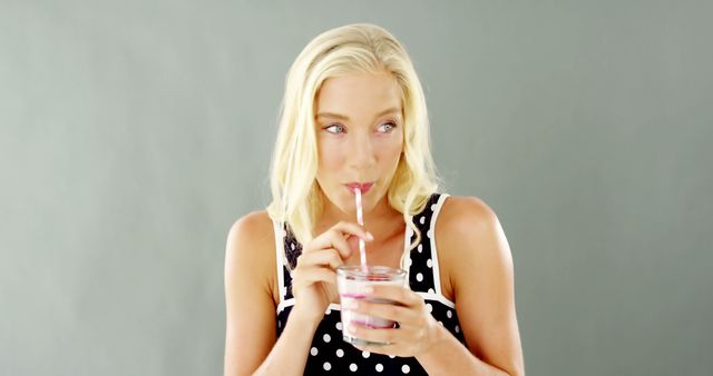 Blonde Woman Drinking Smoothie in Polka Dot Dress - Download Free Stock Images Pikwizard.com