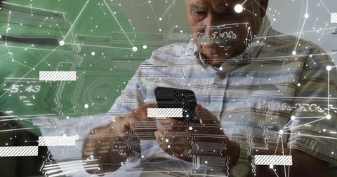 Senior man using smartphone with augmented reality data overlay while reviewing documents