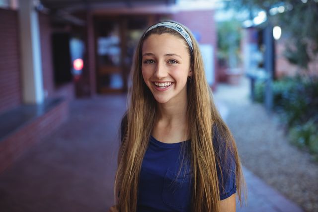 Portrait of happy schoolgirl standing in school campus