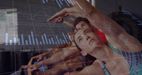 Women reaching and stretching in group fitness class with digital analytics overlay