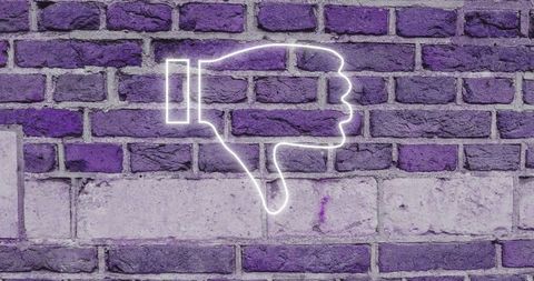 Neon thumbs down sign on purple brick wall