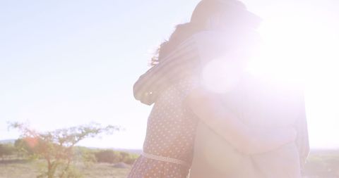 Embracing silhouettes outdoor backlit by sunlight evoking warmth
