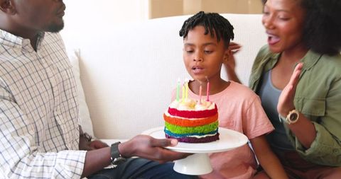 Family Birthday Celebration With Rainbow Cake and Candles