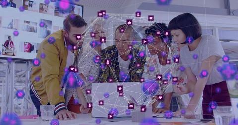 Creative team collaborating over laptop with network overlay for social media strategy