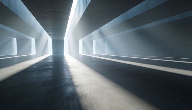 Minimalist concrete corridor with dramatic skylight beams, polished floor, strong shadows