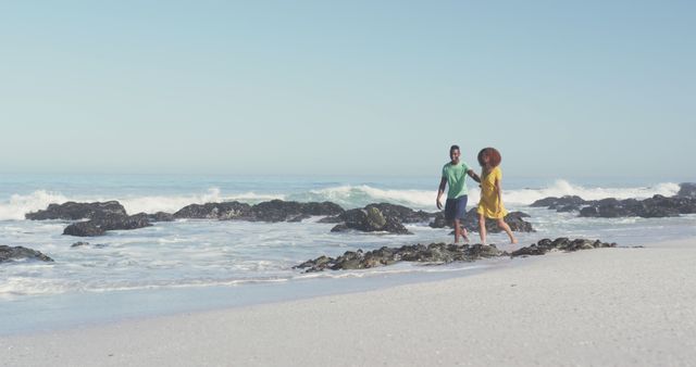 Happy biracial couple walking together in the sea on sunny beach - Download Free Stock Photos Pikwizard.com