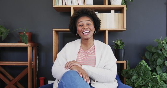 Smiling Woman Relaxing at Home Office with Plants and Bookshelves - Download Free Stock Images Pikwizard.com