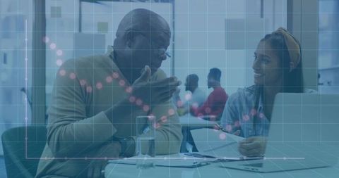 Senior mentor discussing feedback with young professional in office