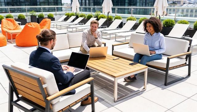 Rooftop collaboration: professionals working on laptops in casual outdoor meeting
