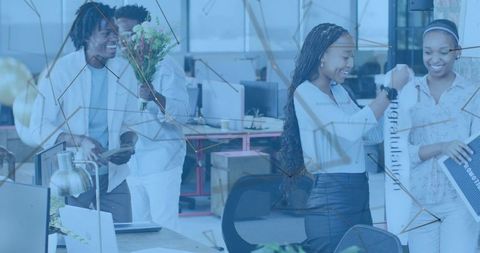 Office team celebrating milestone unrolling congrats banner and holding bouquet