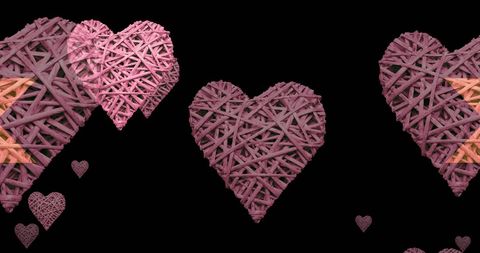 Floating pink woven hearts on black background