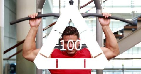 Man performing pulldown exercise at modern gym