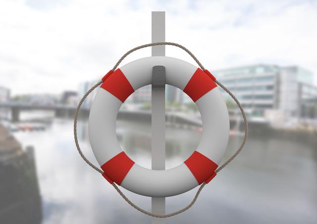 This image captures a close-up of a lifebuoy hanging on a pole near a dock, ready for emergency use. Ideal for illustrations on maritime safety, lifeguard training, outdoor activities, and waterfront themes. Useful for educational materials, posters for safety guidelines, and marketing for beach or waterfront facilities.