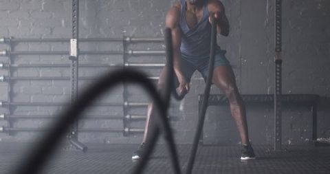 Man Engaging with Battle Ropes for Intense Workout