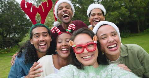Joyful Diverse Friends in Festive Hats Taking Sunny Selfie