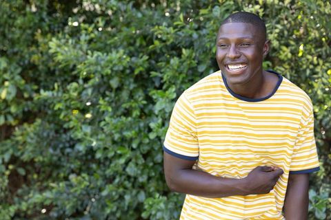 Joyful Man Laughing Outdoors in Casual Yellow Striped Shirt