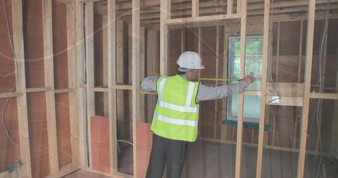 Engineer Measuring Wall Frame at Construction Site