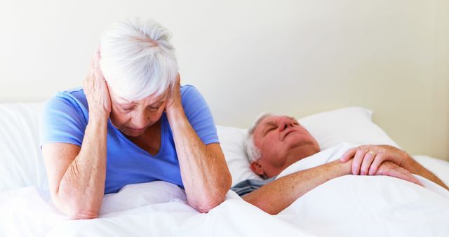 Senior Woman Covering Ears While Husband Snores in Bed - Download Free Stock Images Pikwizard.com