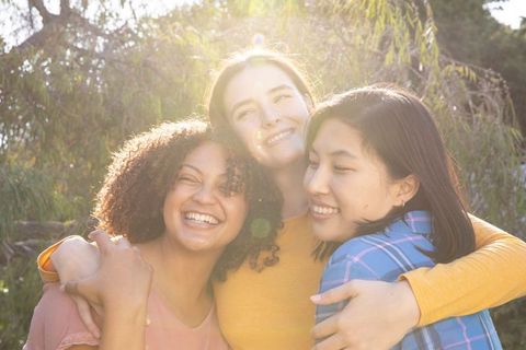 Diverse Group of Happy Friends Embracing in Sunlit Park
