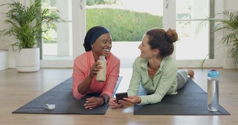 Diverse Women Relaxing with Shake After Home Yoga Session