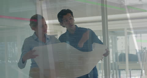 Business Professionals Analyzing Blueprint with Financial Data Overlay