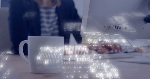 Business professional typing at desk with technology overlay